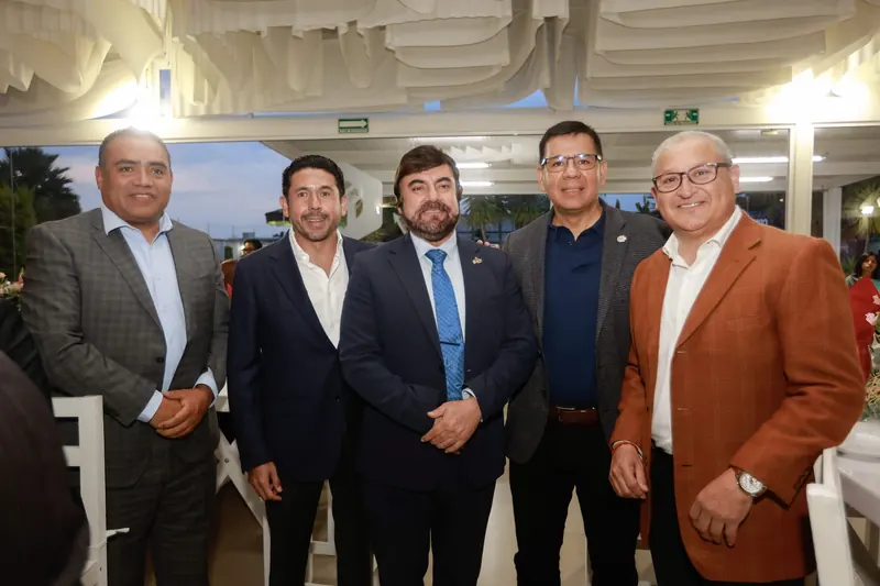 Cinco asistentes posan juntos durante un evento nocturno