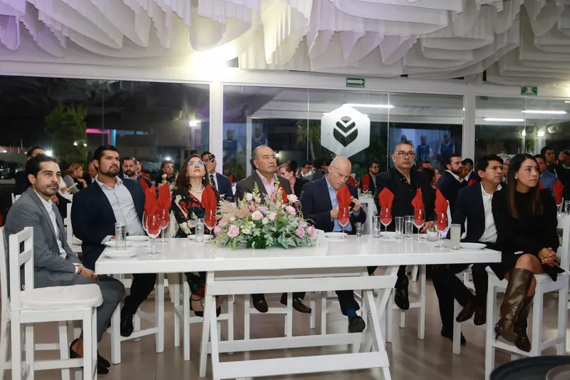 Asistentes sentados a la mesa durante una cena institucional